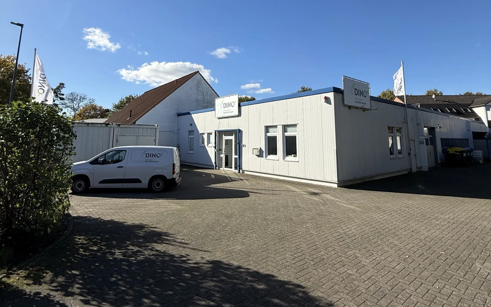 Betriebsgebäude der DINO Dampferzeuger GmbH in Bremen-Huchting mit Firmenfahrzeug und Fahnen